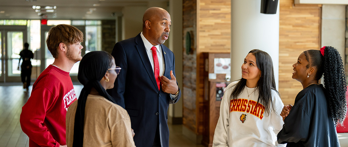 a man talking with younger college students