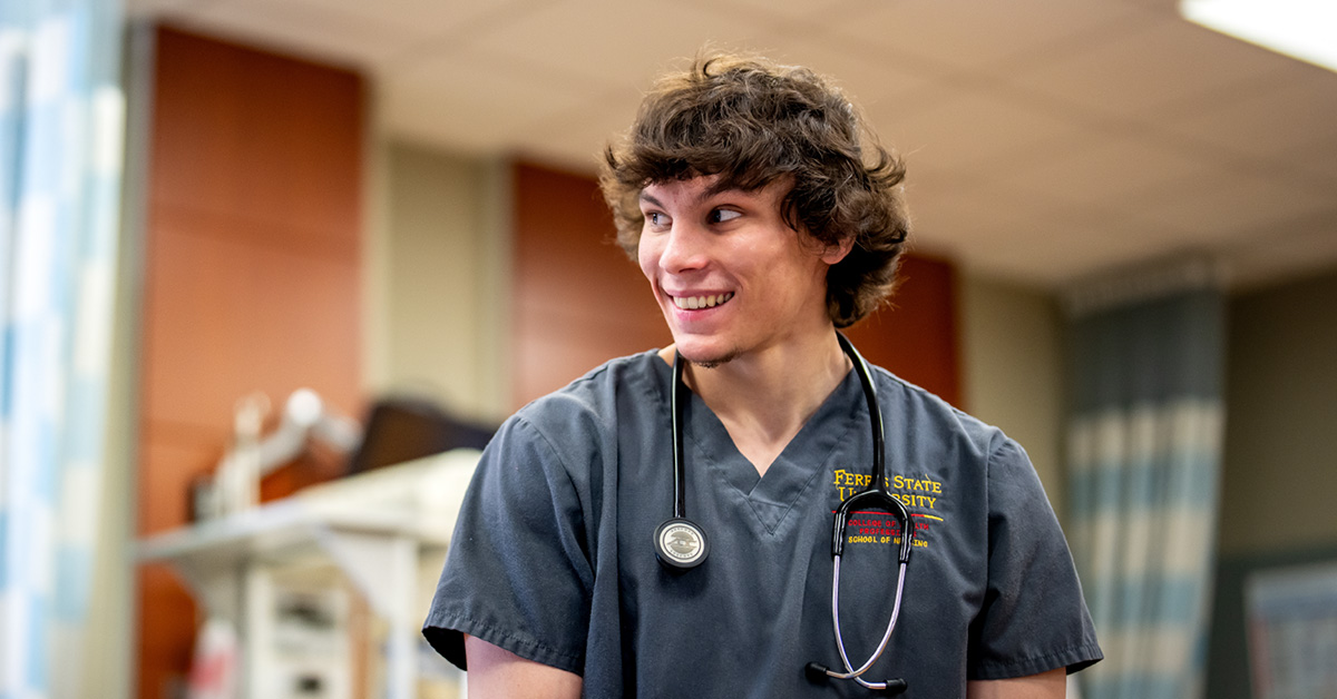 A Ferris State University student dressed in nursing scrubs and a stethoscope