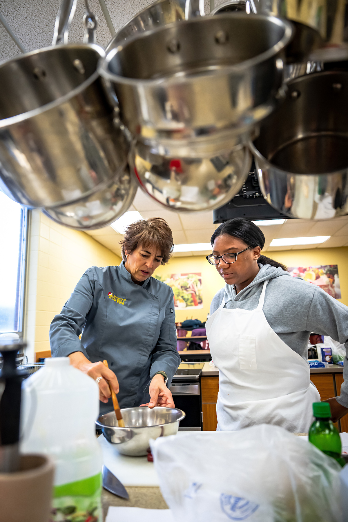 Hospitality Management associate professor Kathryn Wolfer works with a student in class at Ferris State University.
