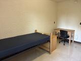 A photo of a bed, dresser, and desk in a room