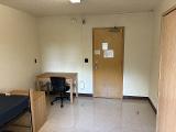A photo of a bed, dresser, desk, and wardrobe in a room