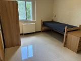 A photo of a bed, dresser, and wardrobe in a room