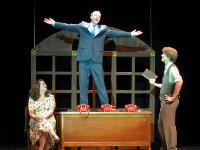 The main character dancing on top of his office desk