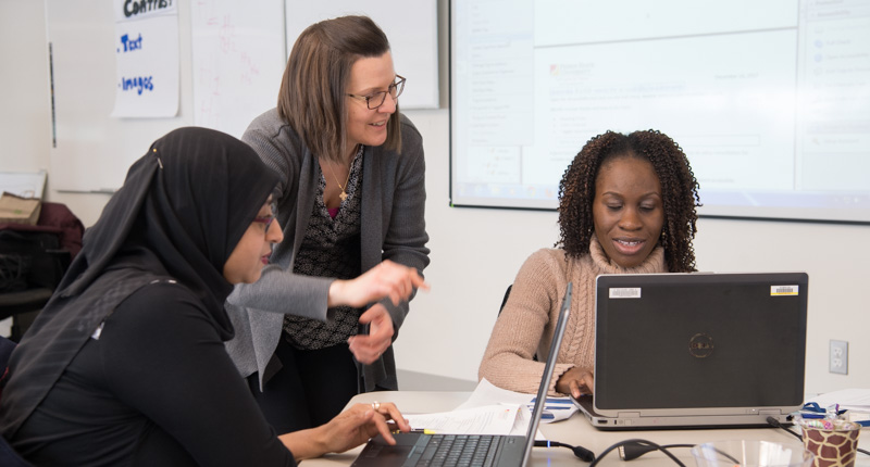 Jody, the manager of the Staff Center, engages with two faculty members during a workshop.