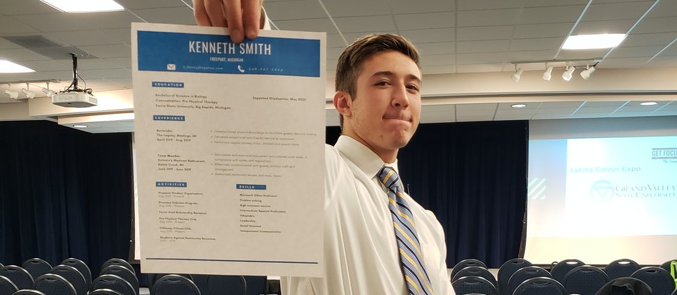 Student holding up a resume for the camera to see