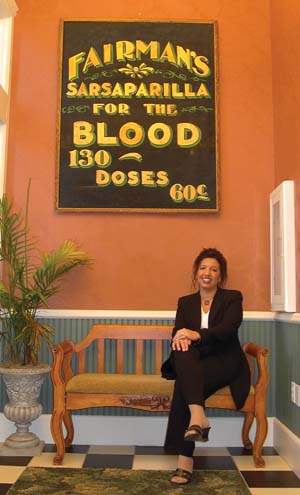 Lisa Wall sitting in front of an historic Fairman building sign