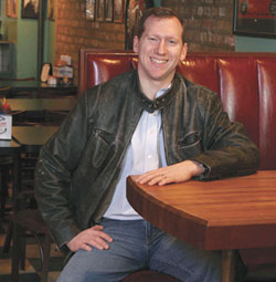 Derek Rettell sitting in a restaurant booth