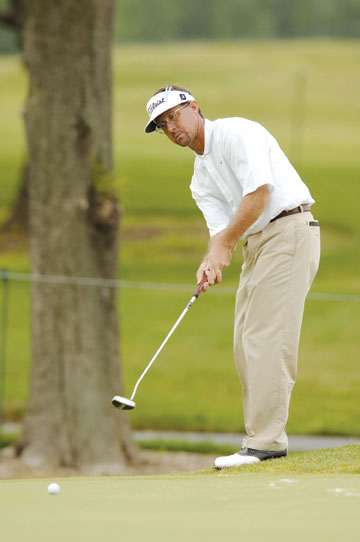 Alan Morin watching his putt on a golf course green