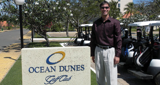 Josh Bannister standing next to the Ocean Dunes Golf Club sign