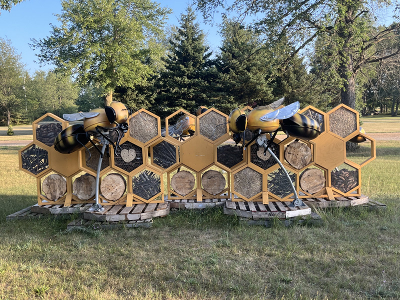 A large sculpture of a beehive complete with metal scupltures of bees