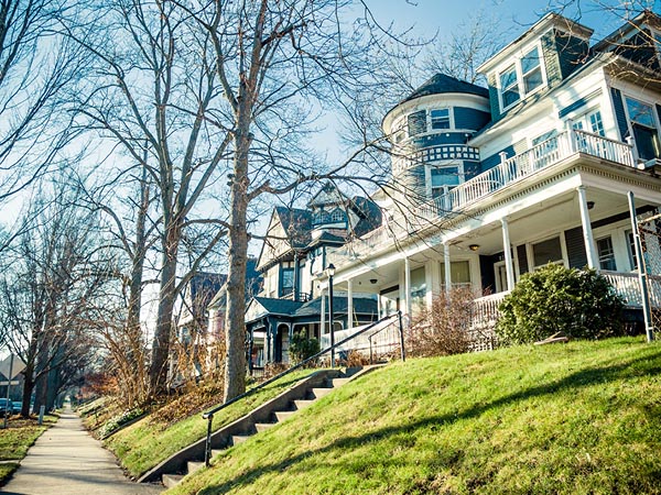 A view of a neighboorhood looking down a sidewalk