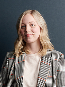 Portrait of a woman with shoulder-length blond hair wearing a white and black checkered blazer and a white undershirt