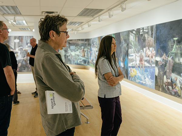 A group of people viewing Boyd Quinn's paintings in the KCAD Spark Gallery.