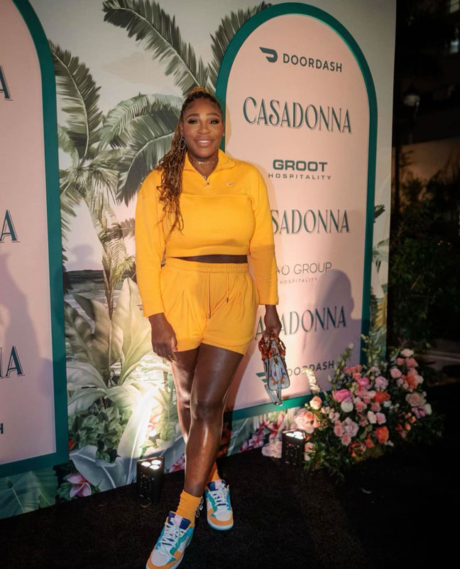 A woman in a yellow umpsuit modeling on a runway