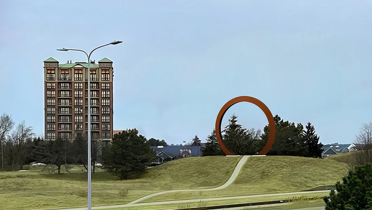 A sculpture appearing as a large, red ring sitting on a grassy hillside