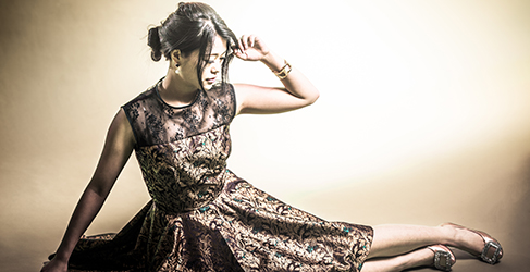 Woman sitting on the ground wearing a gown