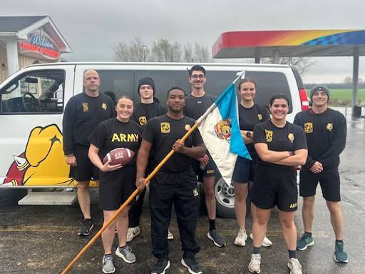 Ferris students pose for a team picture infront of a Ferris van