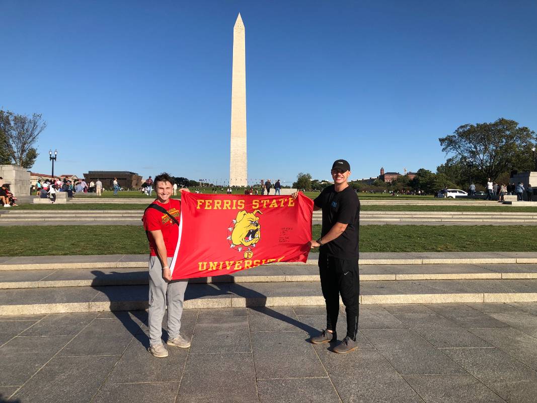 Two Ferris State Cadets by the Washington Monument with a Ferris Flag