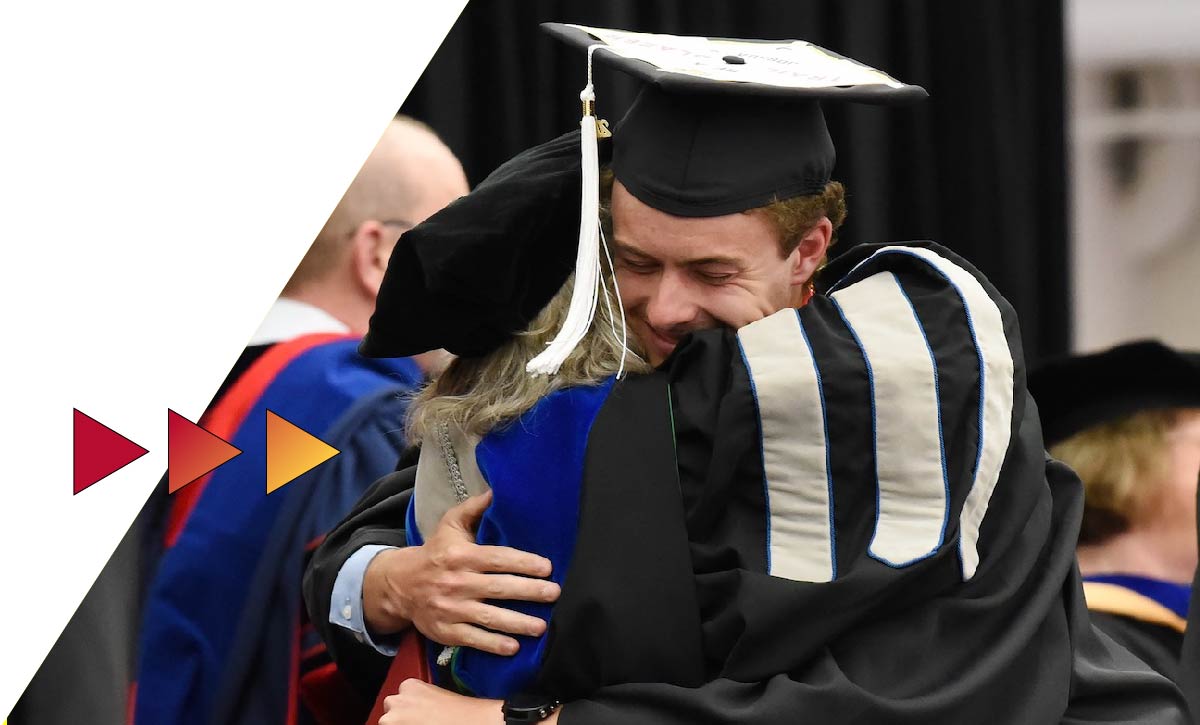 Student hugging professor at Ferris State commencement ceremony