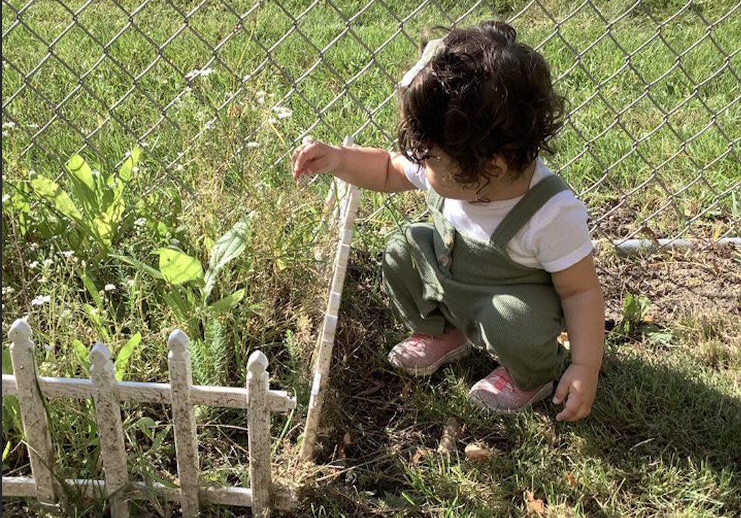 baby outside with plants