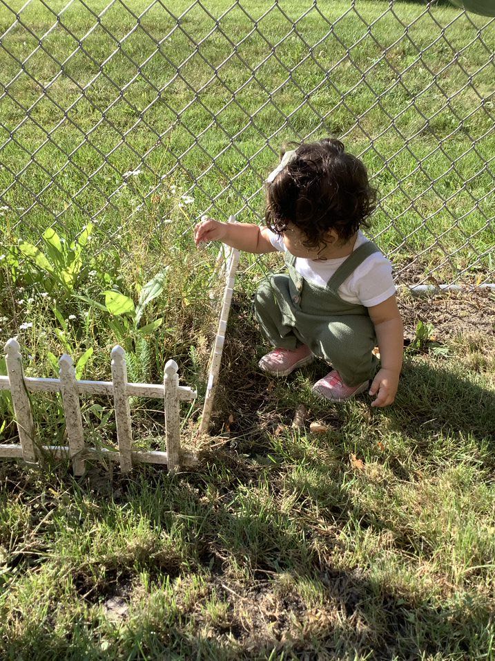 baby outside with plants