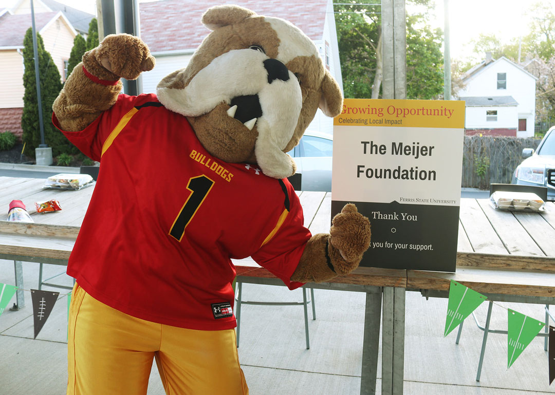 Brutus flexes next to a Meijer Foundation sign.