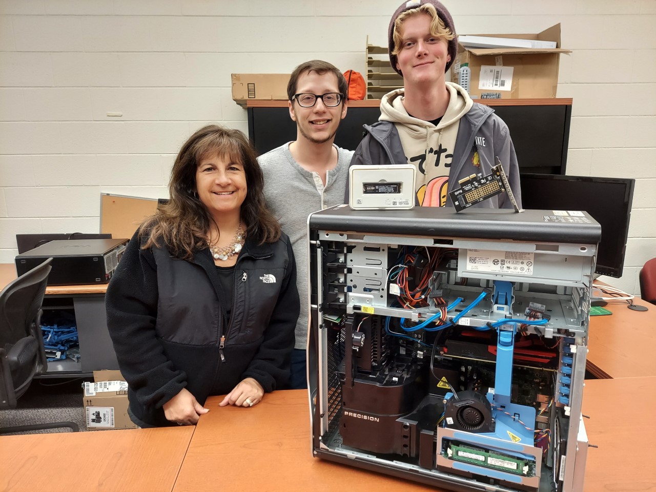 Mary Holmes and student employees stand with rebuilt computers
