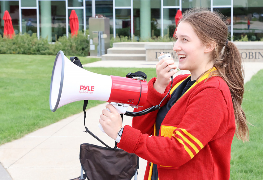 Thumbnail for ODFD24 Sign Up tutorial, photo of student smiling with megaphone 