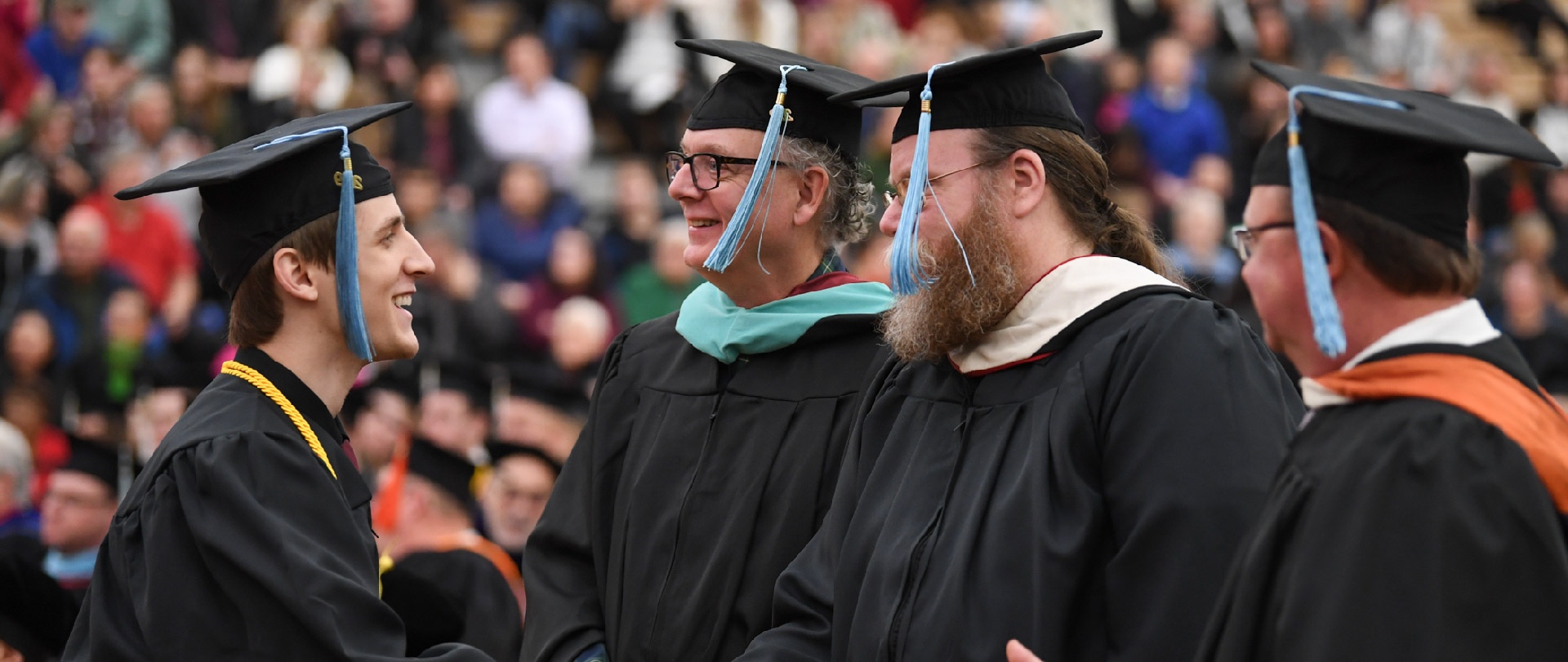 Student walking across graduation stage for hand shake