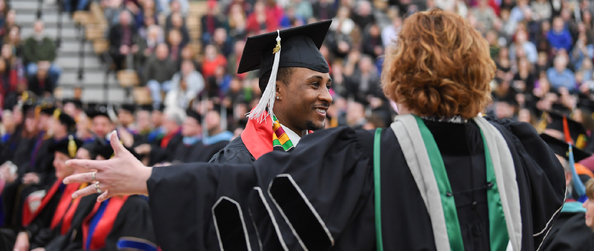 Student and a faculty member at a commencement ceremony
