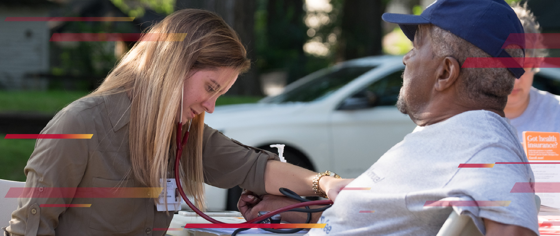 Student taking the blood-pressure of a man