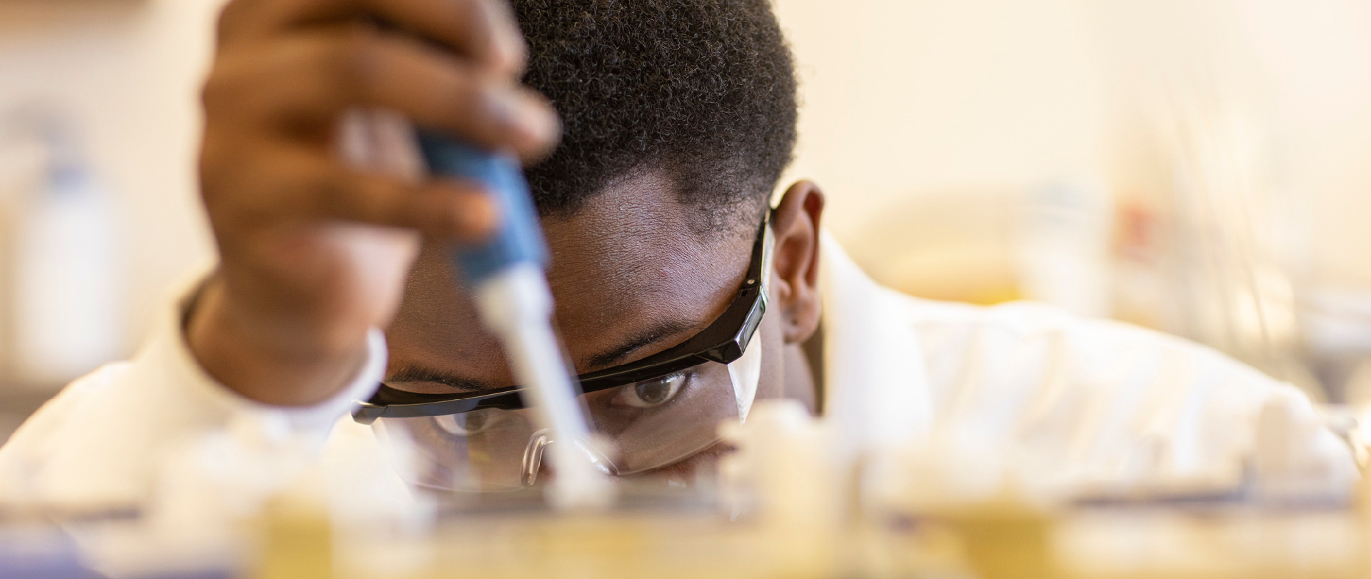 Student using a pipette in a lab at Ferris