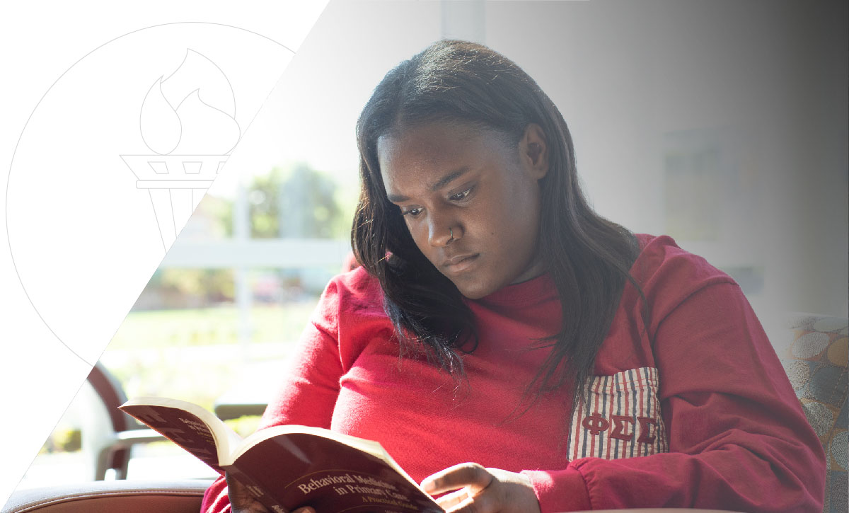 student reading a textbook in the David L. Eisler Center at Ferris State University's campus in Big Rapids, MI