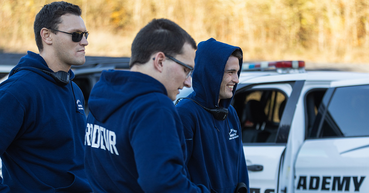 ferris state university police academy students standing next to a police vehicle
