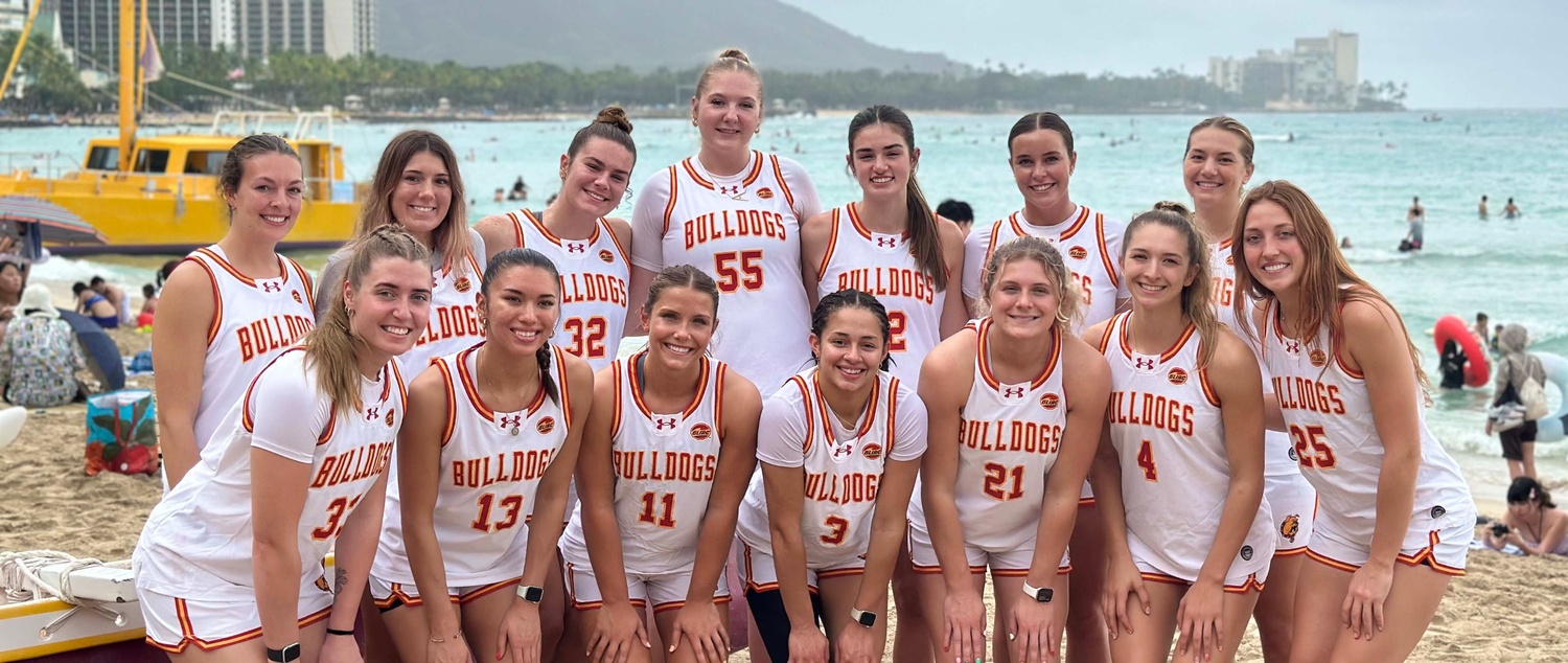 Women's basketball team posing on the beach in Hawaii