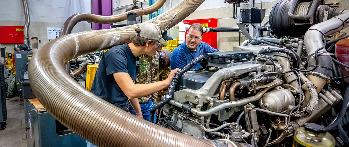 two people working on heavy equipment