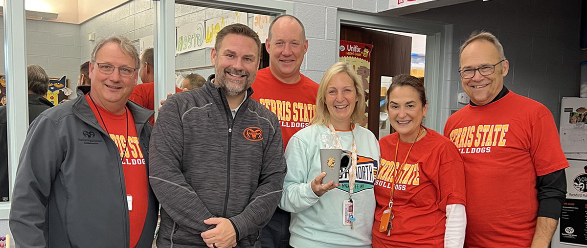 six people posing together wearing Ferris State clothing