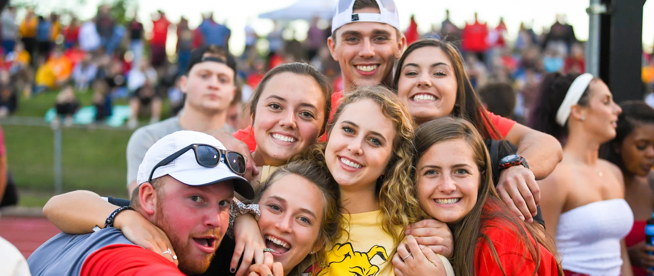 group of students smiling at the camera at a football game