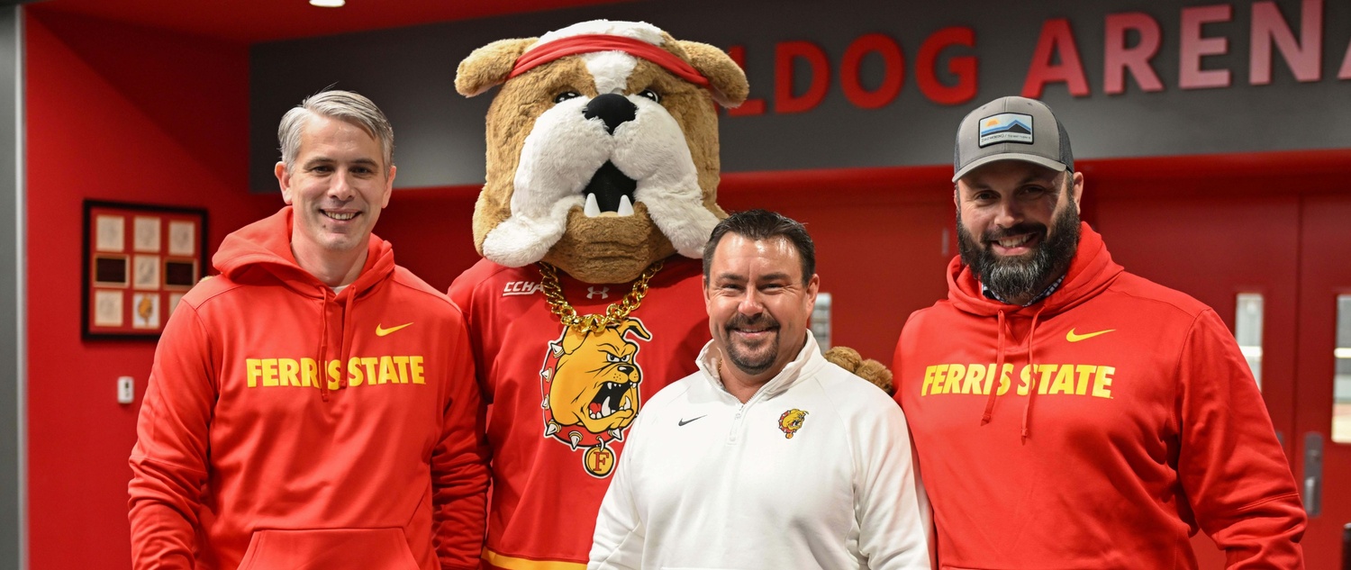 Zachary Nykodym standing with Bulldog graduates and Brutus the mascot
