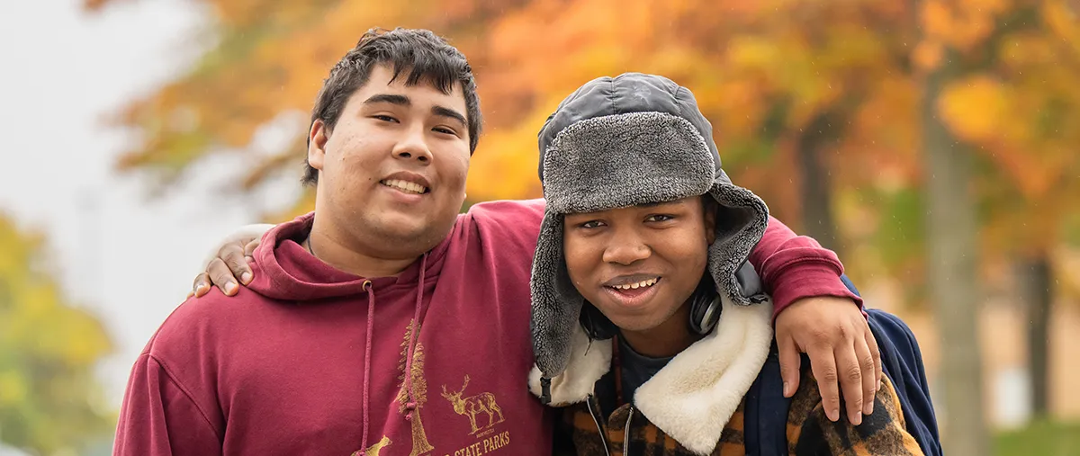 two students outside in the fall