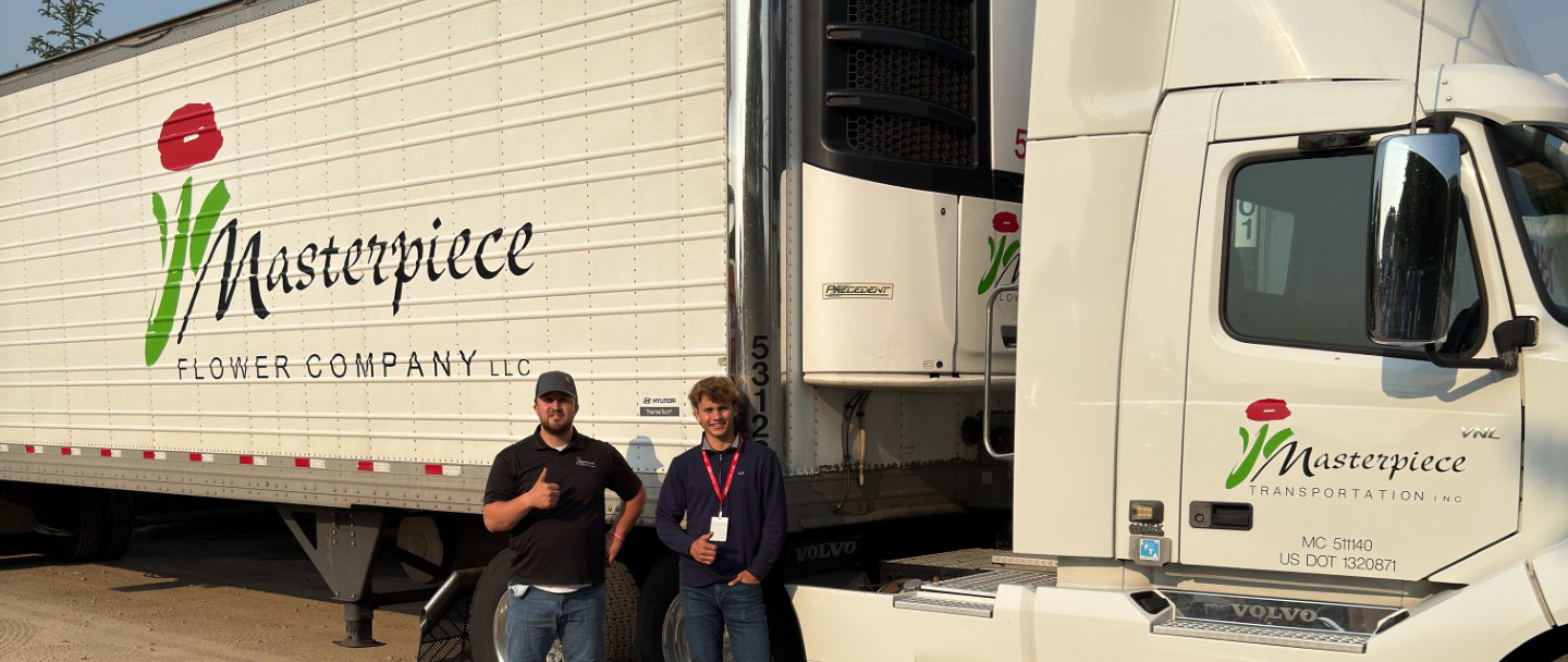 Henry Mast and a staffer posing in front of a Masterpiece Flower Company truck.