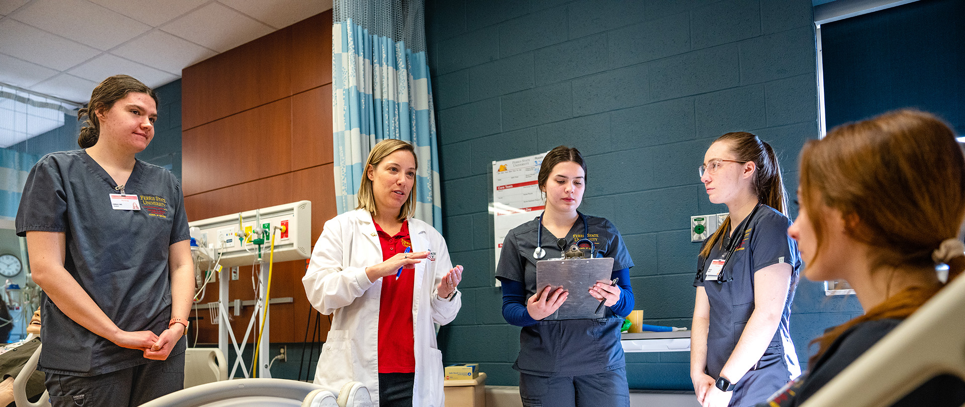 Students and an instructor working in a classroom simulation of a hospital room at Ferris State University.