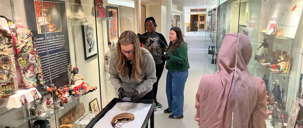 Volunteers carefully pulling artifacts from display to put into storage