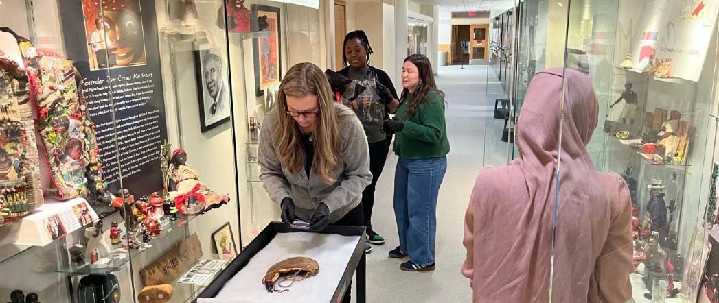 Volunteers removing artifacts from display to prepare them for the storage and transportation process