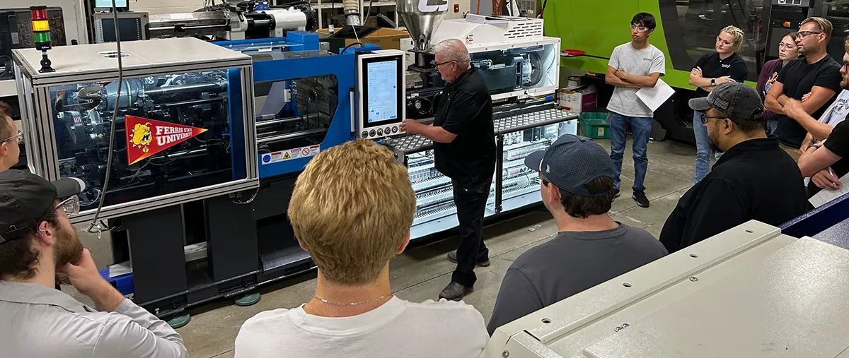 students around a new injection molding machine