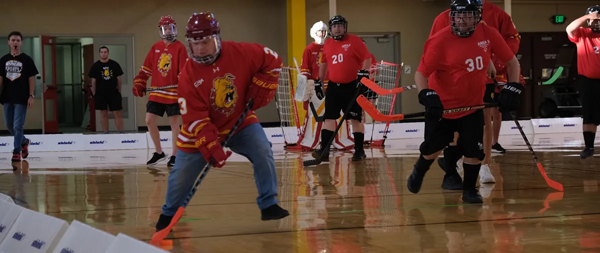 people playing hockey in a gymnasium