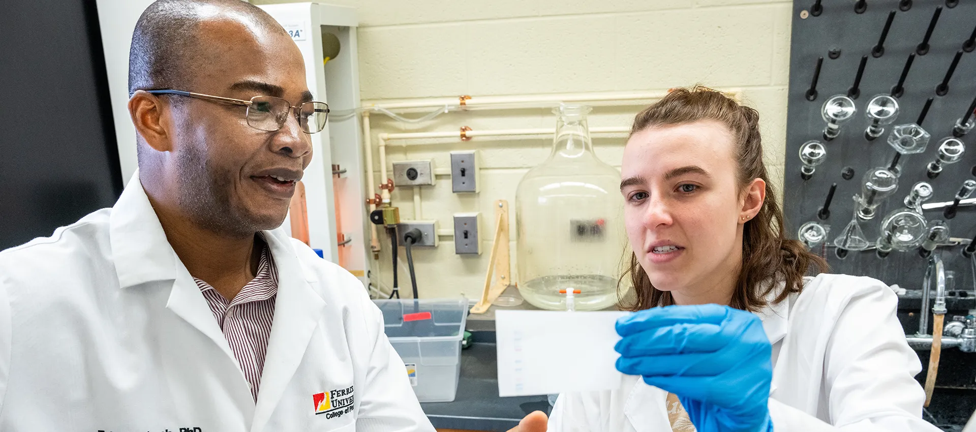 Student and faculty member using lab equipment