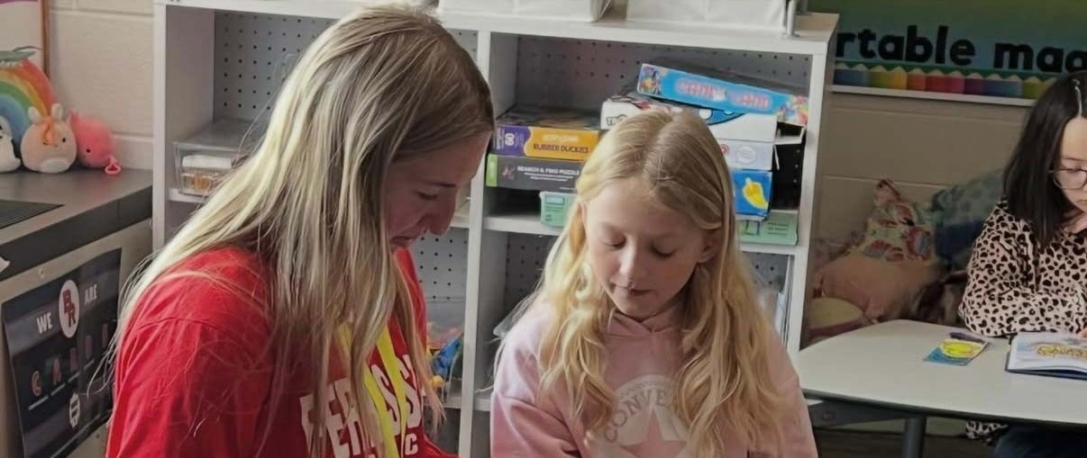Ferris State student helping an elementary student