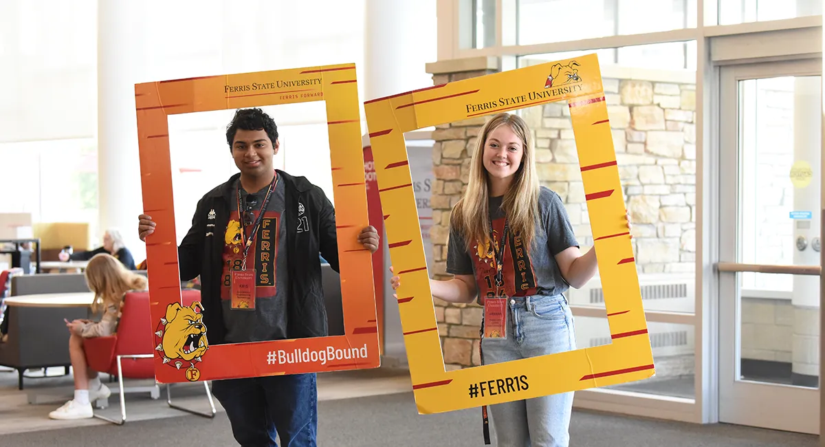 Two students posing with a picture frames on a college campus visit at Ferris State University in Big Rapids MI