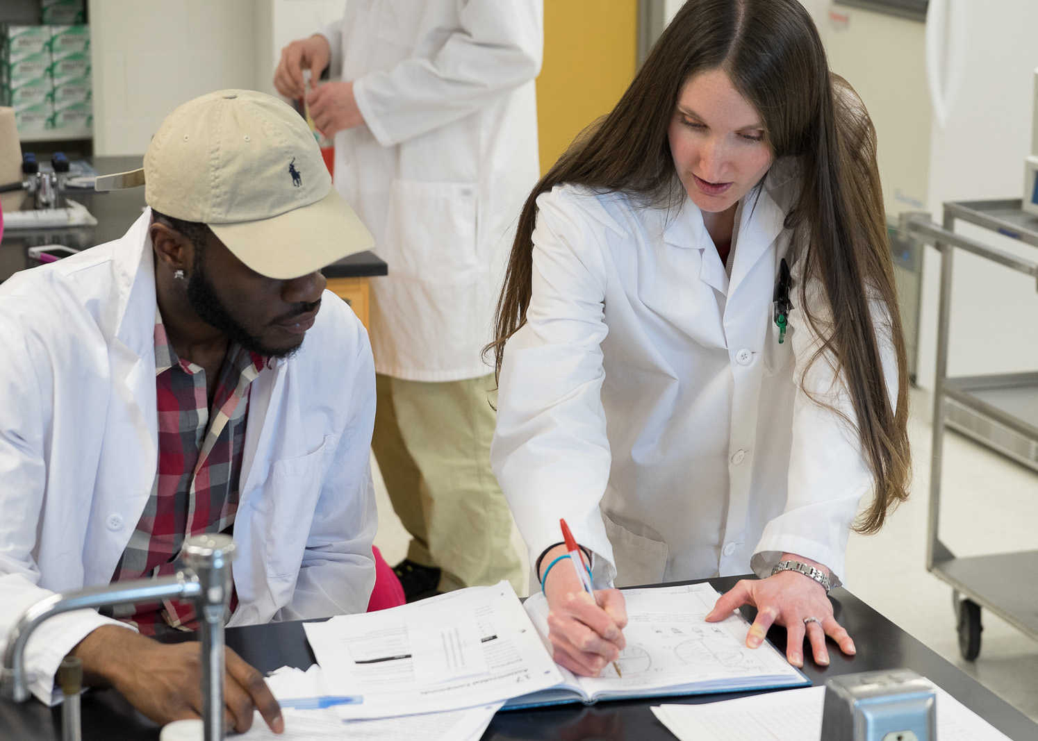 biology student with faculty looking at paperwork in a lab